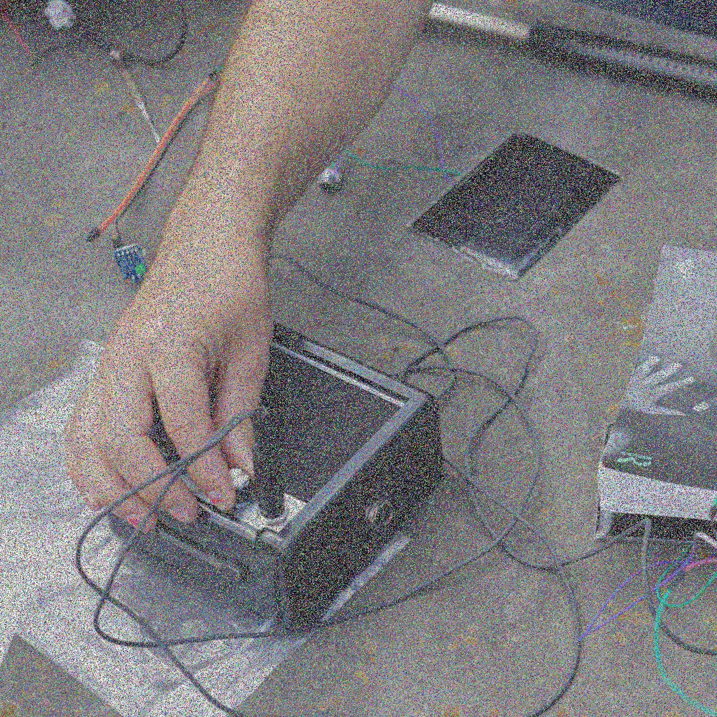 Een hand draait de knop op een luidspreker van een schijnbaar zelfgemaakt sonisch elektronisch circuit.