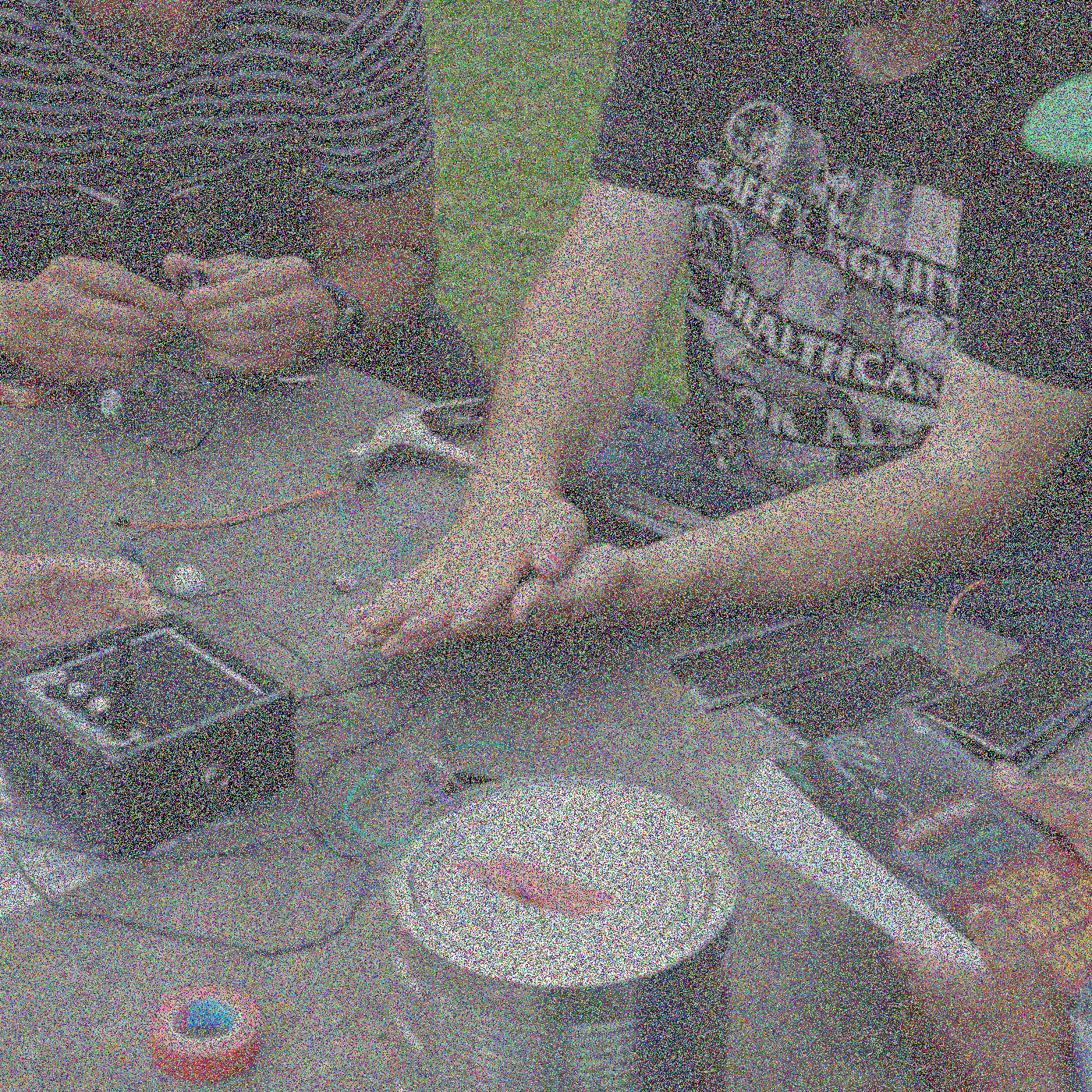 Geanonimiseerde handen zijn bezig met elektronica op een tafel, inclusief kabels, enkele zonnepanelen en een luidspreker.